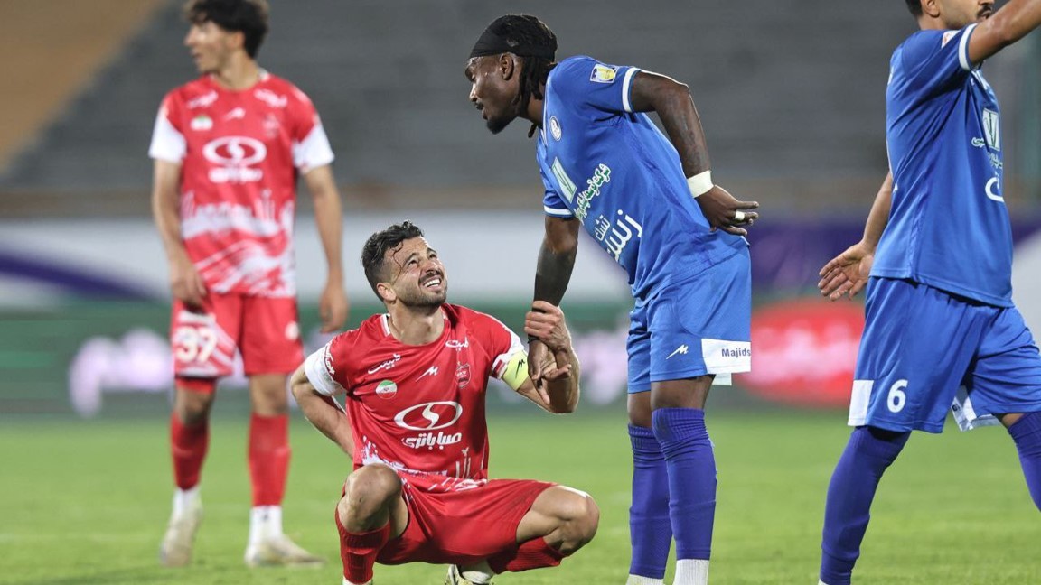 تیوی بیفوما مهاجم استقلال خوزستان در حال دست دادن با سروش رفیعی هافبک پرسپولیس